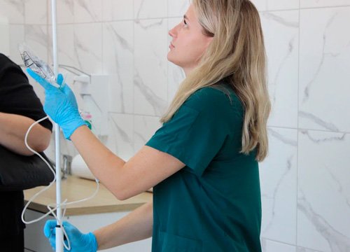 Врач подготавливает капельницу